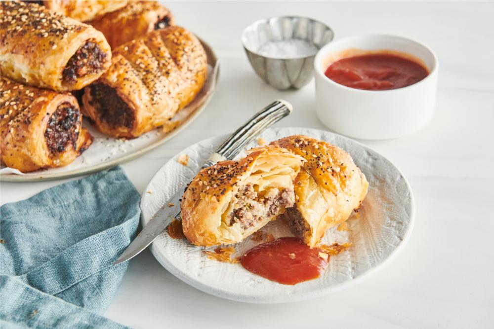 There’s nothing quite like biting into a warm sausage roll encased in flaky, buttery pastry. And with this easy recipe for beef and caramelised onion sausage rolls, you can easily whip up a batch of these comforting treats at home. This recipe is incredibly versatile, allowing you to create bite-sized snacks for parties or satisfying mid-size treats for a filling lunch. Whether you're feeding the little ones or impressing guests at a gathering, everyone will love these delicious sausage rolls. So why not give it a try and bring some cozy comfort to your next meal.