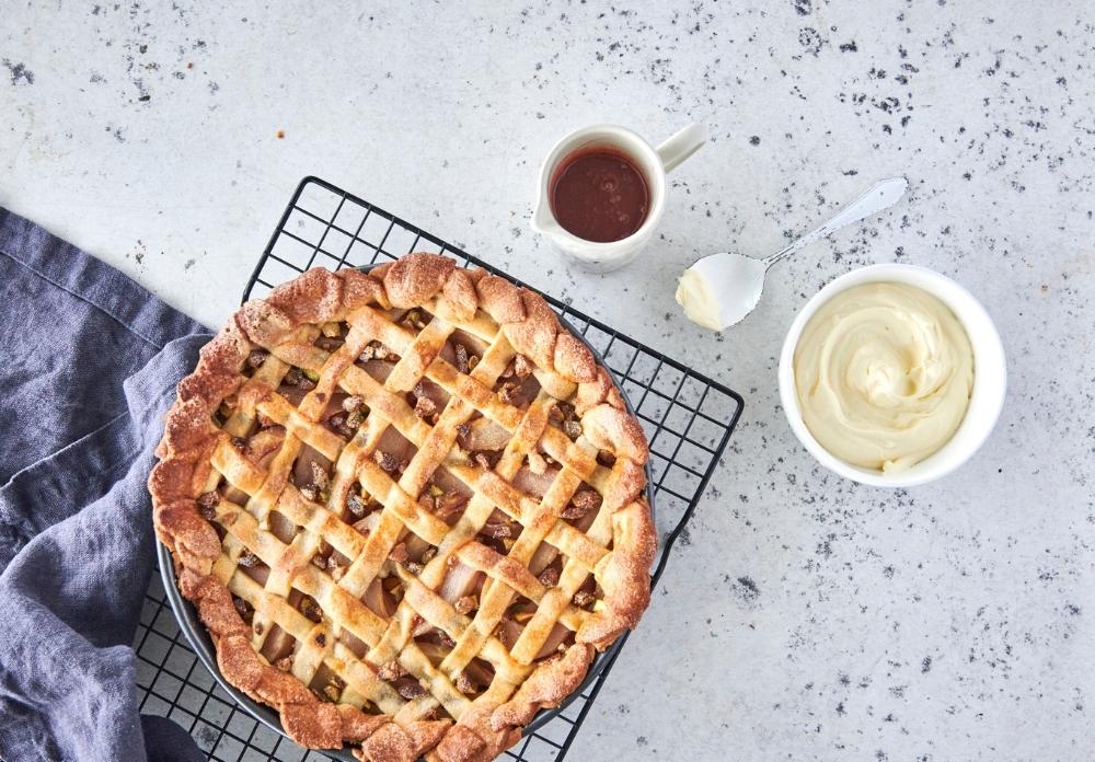 This stunning winter warmer pie is one for the true lovers of a decadent dessert. Filled with rosé-infused pears, vanilla, cardamon and pistachios,  all encased in a visually stunning and obscenely delicious sweet vanilla shortcrust lattice top and base, you'll love it served warm with rosé butter and dollop cream.