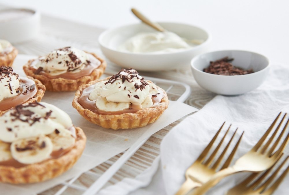 Sweet and decadent, these little banoffee pies have it all! The rich salted caramel filling is topped off with banana, fresh whipped cream, and grated chocolate, all nestled inside a super crisp sour cream pastry shell kids and adults alike will love.